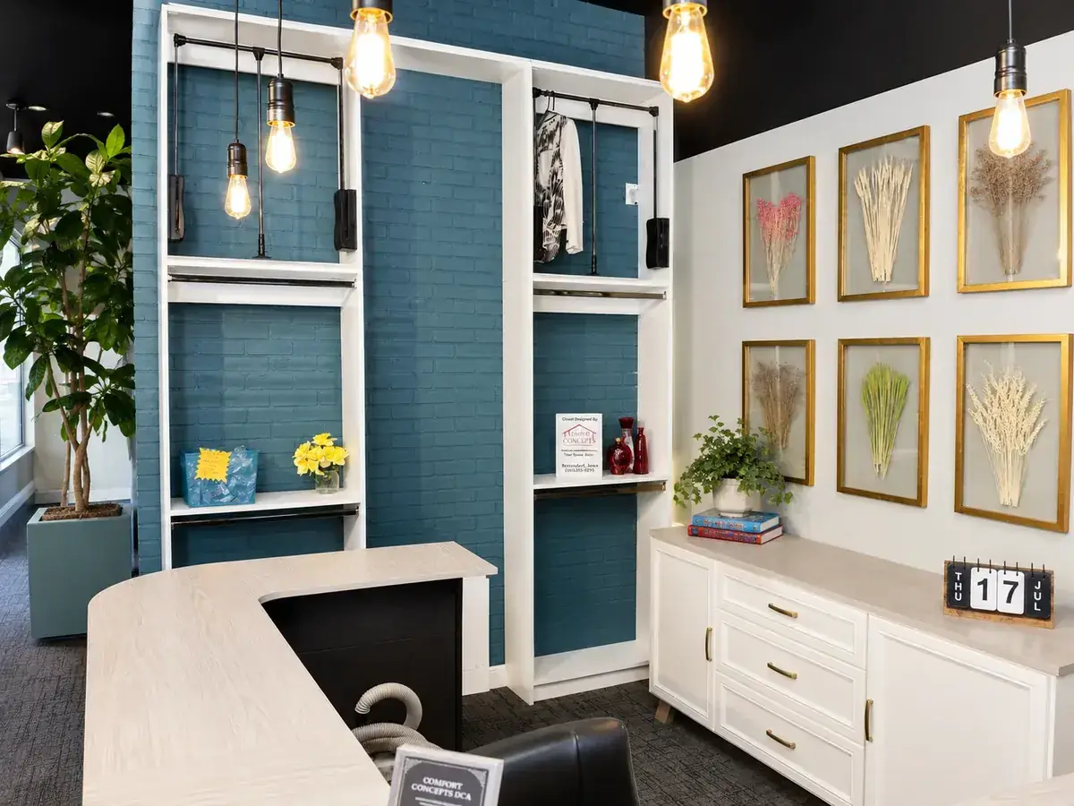 Comfort Concepts QCA design center interior — teal brick accent wall, Edison lights, and custom home office display